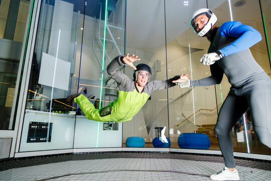 Instructor giving training to participant at indoor skydiving center