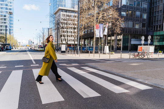 Fashionable businesswoman crossing street in city