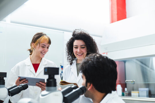 Smiling scientists discussing in laboratory