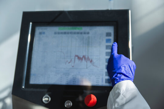 Hand of scientist operating bioreactor in laboratory