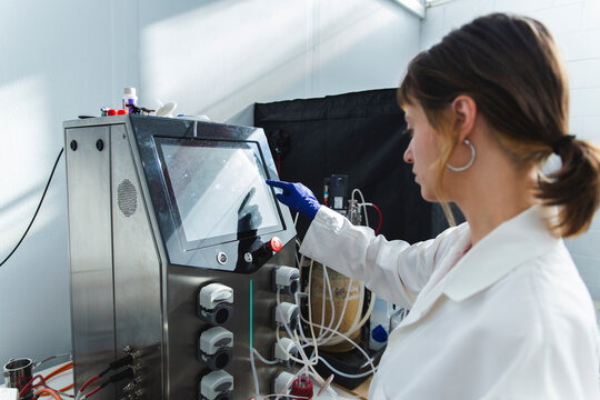 Scientist operating bioreactor in laboratory