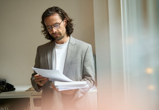 Confident businessman analyzing document at office
