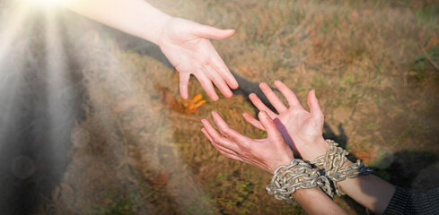 Bound hands reach out to the outstretched hand for help