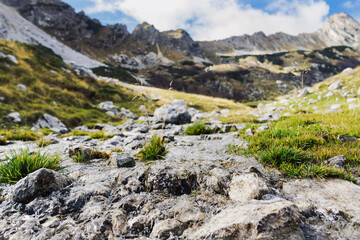 Mountain stream in good weather. Mountain landscape and sky with clouds. Selective focus in the foreground