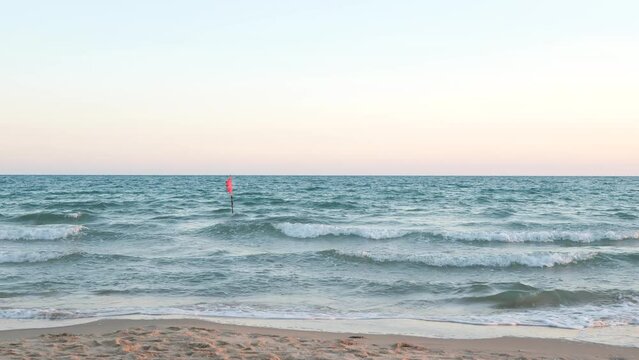 Red flag warning at the sea with high tide waves as signal for danger and hazard rip current activity in Thailand.