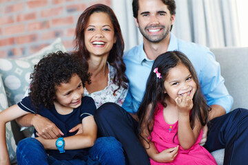 Portrait, smile and family in home on sofa for care, support and funny interracial people bonding...