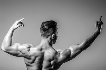 Man Power. Perfect Shoulders and Back Muscles. Muscular Man showing Strength, Back view. Sexy body....