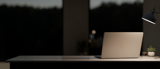 A back view image of a laptop computer on the table in a modern, dark room at night.
