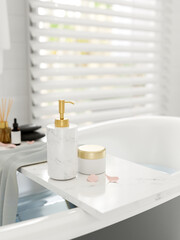 A luxury white marble bathtub tray on a bathtub in a modern white bathroom.