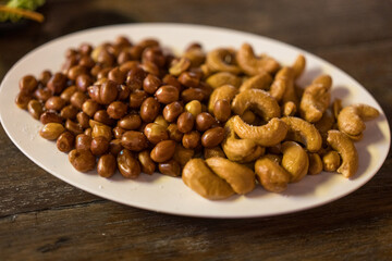 Fresh roasted salted peanuts and cashew on the table dinner party