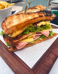 Club Sandwich with hand eggs lettuce cheese and chicken on toasted bread