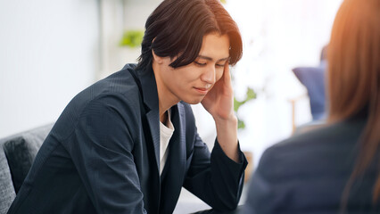 ソファに座って会話する男性
