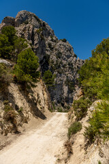 Dirt track through wilderness area, Paso el Contador - the pass between Sella and Guadalest valley, Alicante, Spain - stock photo