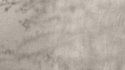 Abstract floral sunlight shadows on neutral light taupe beige linen cloth background, soft sustainable backdrop in earthy colors