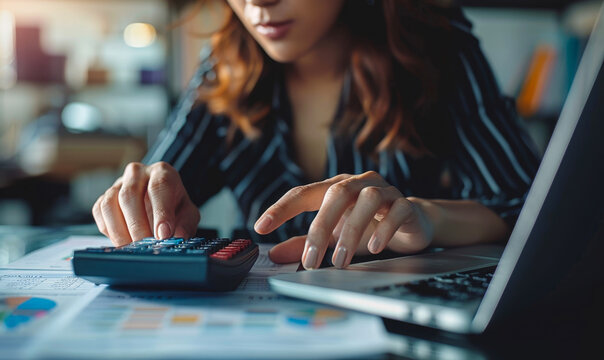 Professional businesswoman calculating financial reports and expenses on calculator, focused laptop work for budget management, number crunching for investments