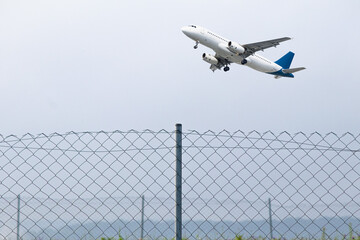 Passenger plane flying behind stainless steel fencing wire. Aviation idea concept. Deported....