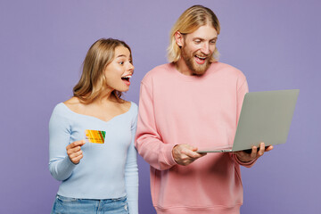 Young couple two friends family IT man woman wearing pink blue casual clothes together use laptop...