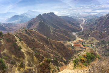 Fototapeta na wymiar Aerial view of mountains ridge, river, village, road in the canyon to the monastery. Shio-mgvime monastery.