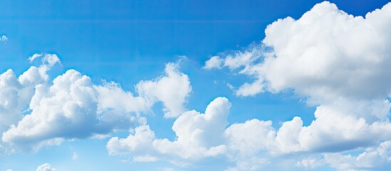A serene blue sky with fluffy white clouds providing a perfect copy space image