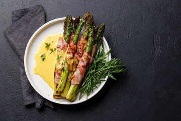 Grilled asparagus with bacon and egg sauce on a plate