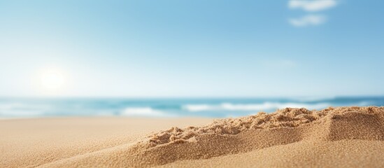 Sand in a close up shot with a blurry background of the sea and sky on a sunny summer day suitable for product placement with copy space image