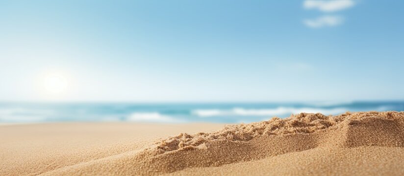 Sand in a close up shot with a blurry background of the sea and sky on a sunny summer day suitable for product placement with copy space image