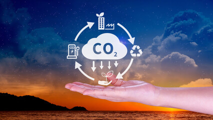 Hand holding CO2 reducing virtual icon for decrease carbon dioxide emission, carbon footprint and carbon credit to limit global warming from Bio climate change concept.