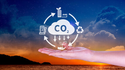 Hand holding CO2 reducing virtual icon for decrease carbon dioxide emission, carbon footprint and...