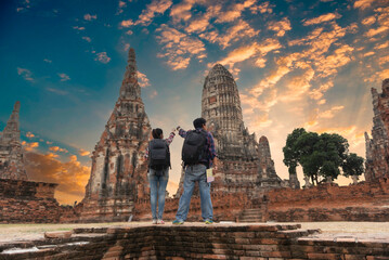Tourists with map in hand looking at a temple in Ayutthaya, Thailand at Wat Mahathat