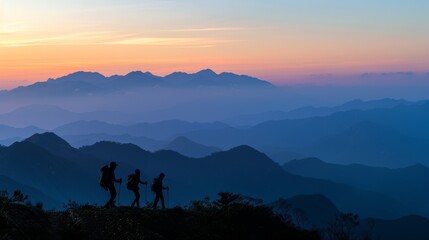 Fototapeta premium Breathtaking mountain sunrise panorama with silhouette hikers. Silhouettes of hikers reaching a mountain peak at sunrise.