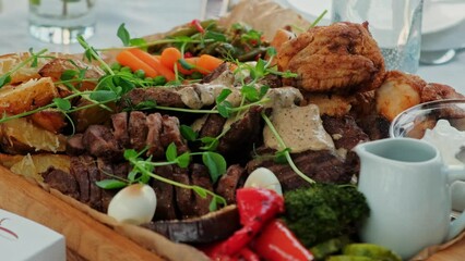 A platter of assorted grilled meats, fresh vegetables, and dipping sauces ideal for dining and culinary presentations.