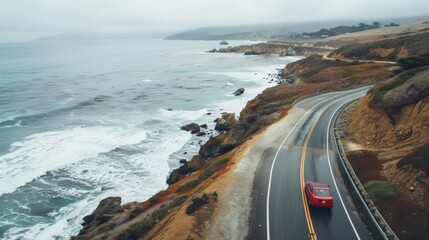 Fototapeta premium Scenic coastal highway road trip with crashing waves. Winding road along coastline, blue ocean water, and dramatic cliffs.