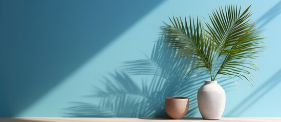 Obraz premium Luxurious summer interior design with subtle product placement featuring a palm shadow on a blue plaster wall creating a chic bohemian ambiance for a product platform stage mockup with copy space imag