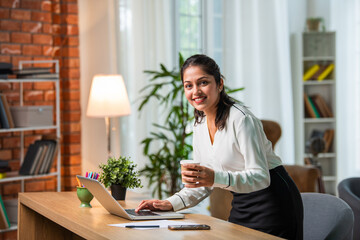 Indian asian young beautiful female business woman working on laptop on table or desk