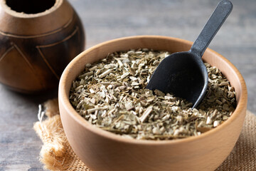 Traditional yerba mate in bowl on wooden table