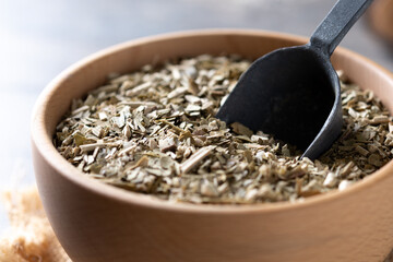 Traditional yerba mate in bowl on wooden table. Close up