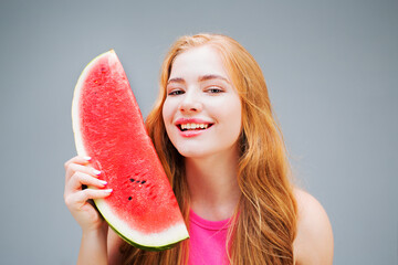 Happy young beautiful woman eating watermelon isolated on gray background. Healthy eating concept....