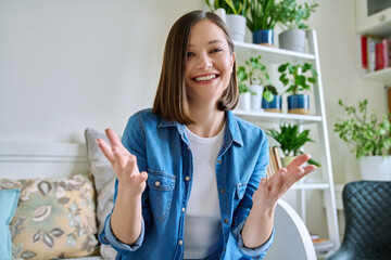 Web cam view of young attractive woman talking in home interior