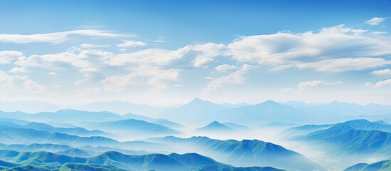 The mountains are beautifully accentuated by a picturesque blue sky and fluffy white clouds creating an ideal copy space image