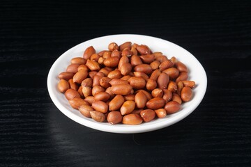 raw peanuts on a black background with studio lighting