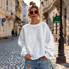 Obraz premium a woman wearing a white top and jeans stands on a cobblestone street.