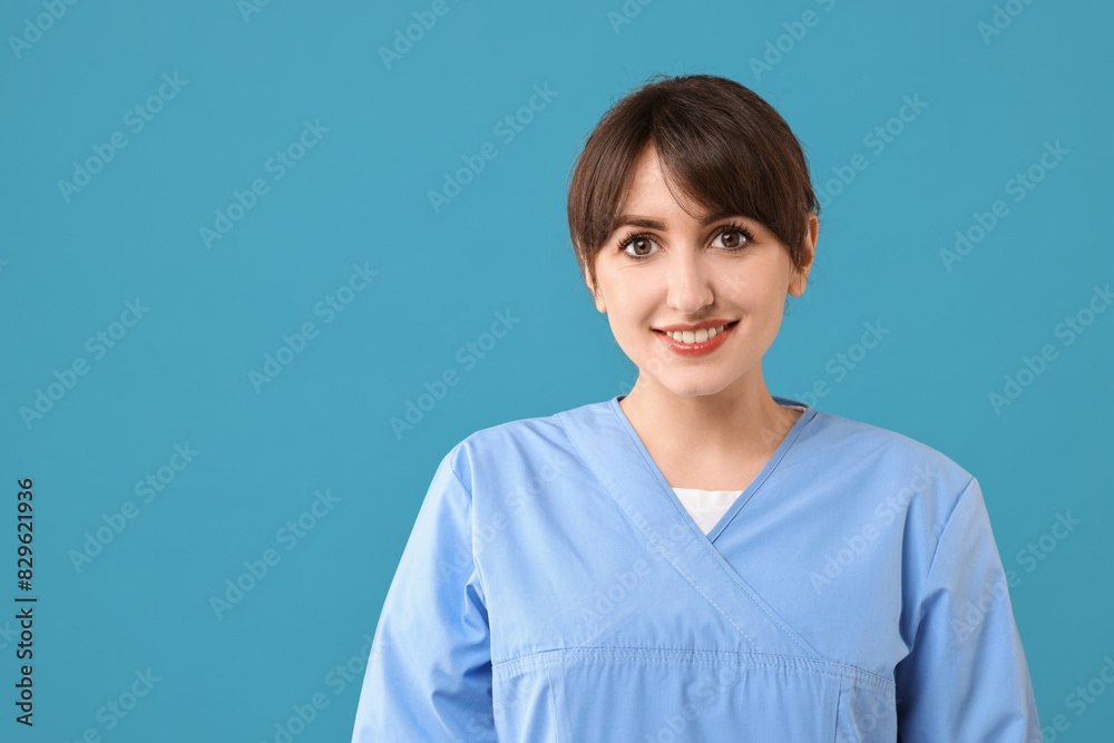 Wall mural Portrait of smiling medical assistant on light blue background. Space for text