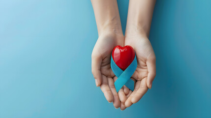 Top view blue ribbon with red drop of blood in female hands isolated on blue background with copy space. World Diabetes Day, November 14. June 14, World Blood Donor Day