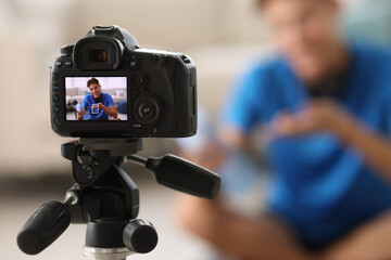 Smiling sports blogger recording fitness lesson at home, focus on camera. Space for text