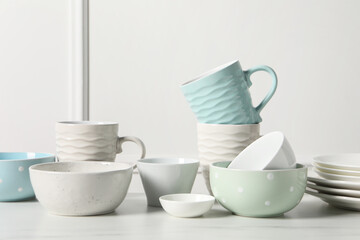Beautiful ceramic dishware and cups on white marble table