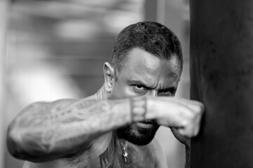A fist of strong man. A man fists clenched in anger. Close-up of face and hand of boxer ready for a fight. Strong arms and clenched fists. Danger look. Sport man exercise outdoor with boxing fists.
