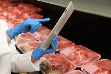 Food quality control specialist examining meat in supermarket, closeup