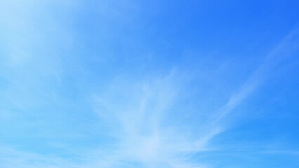 A clear blue sky with a few wispy, white clouds dispersed throughout. The overall atmosphere is...
