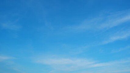 A clear blue sky with subtle gradients of light blue and a few wispy white clouds. The simplicity...