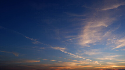 A stunning sunrise with a deep blue sky transitioning into warm hues of pink and orange. Wispy...
